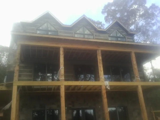 Dormers and porch framing on a large log home under construction — Roof Coating work by our crew in Aiken
