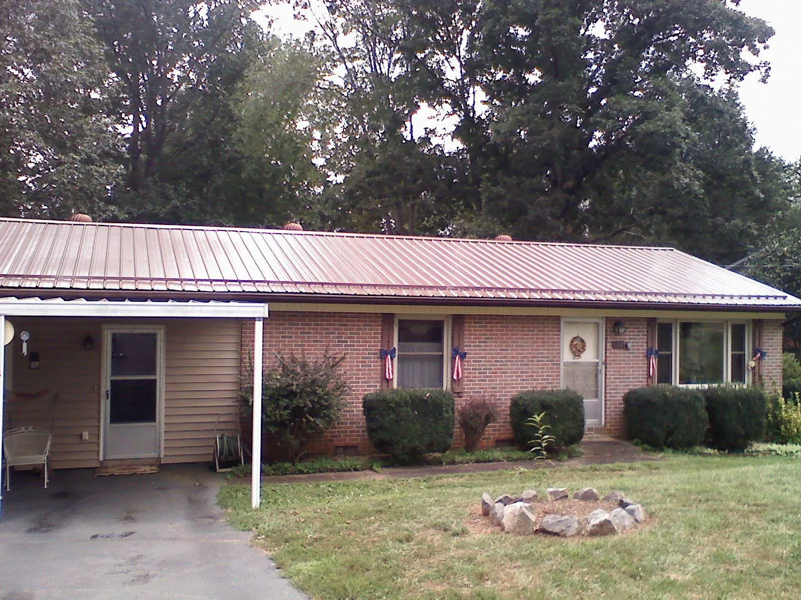 Bronze metal roof and carport on a brick ranch home — Roof Repair work by our crew in Aiken